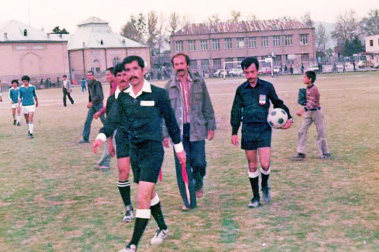 زمین دبیرستان فردوسی روزگاری از زمین‌های مهم فوتبال مشهد بود که مسابقات مختلفی در آن برگزار می‌شد. این عکس مربوط به یکی از همین بازی‌ها‌ست که داوران بعد از پایان مسابقه در حال ترک زمین هستند. در این عکس ازسمت راست، محمد جلالی داور، حسین تهرانی نماینده هیئت برگزاری مسابقات و مهدی پهلوان‌زاده و اسماعیل خرسندی، کمک‌داوران مسابقه، دیده می‌شوند.