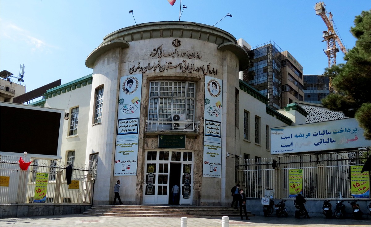 در راسته خیابانی که این روز‌ها بوی سیر صعودی دلار و ارز حسابی شلوغش کرده است، درست در مقابل خیابان امام خمینی (ره) ۲۸ ساختمانی بزرگ با قدمتی بیش از چنددهه قد برافراشته است و تابلوی «اداره کل امور مالیاتی» بر آن خودنمایی می‌کند؛ ساختمانی که باز هم در این هیاهوی ارزی شمار زیادی از شهروندان را به سمت خود فرامی خواند. شهروندان در این ساختمان نه برای سود فردی، بلکه برای جلوگیری از هرگونه جریمه حضور دارند.
